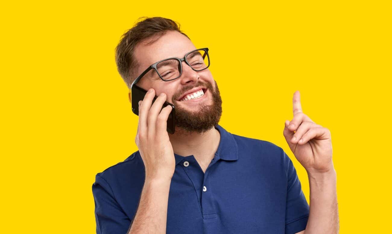 a man laughing while talking on a cell phone